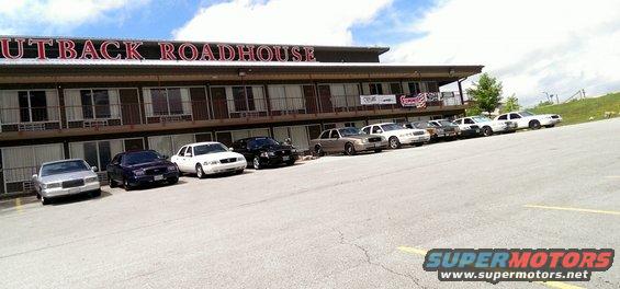 Several Ford Crown Victoria Police Interceptor sedans parked in a row in front of the Outback Roadhouse motel
