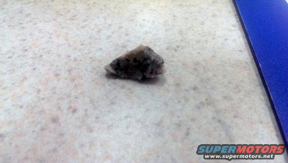 Rock on speckled countertop next to blue binder