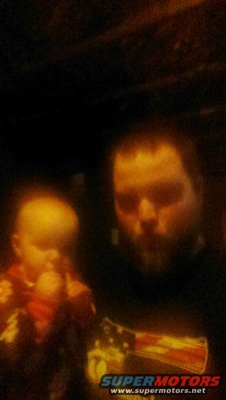 Man and baby, man wears t-shirt with American flag graphic. SUPERMOTORS logo visible