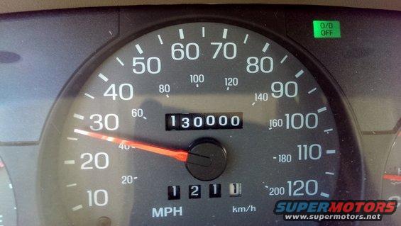 Car dashboard showing speedometer reading 30 MPH and odometer reading 130,000 miles. O/D OFF light is illuminated