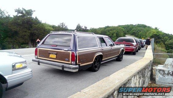 Wood-paneled station wagon with a blue roof, seen from the rear left