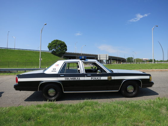 side view of a 1991 Ford Crown Victoria police car with 'TRUMBULL POLICE' on the door