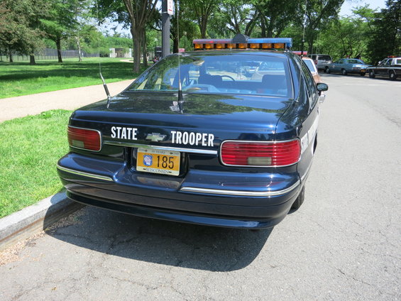 Rear view of a dark blue 1991 Chevrolet Caprice police car with "STATE TROOPER" text and Wisconsin license plate
