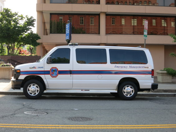 White Ford E-Series van with blue and red stripes and