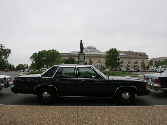 1991 Ford Crown Victoria sedan parked on street with building and statue in background