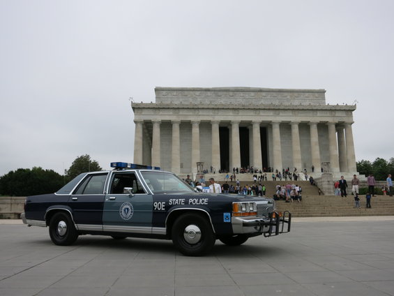 Police car parked in front of the Lincoln Memorial with people on the steps