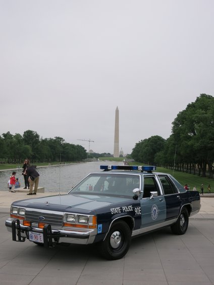 1991 Ford Crown Victoria police car with 'STATE POLICE 90E' on door, parked near Washington Monument