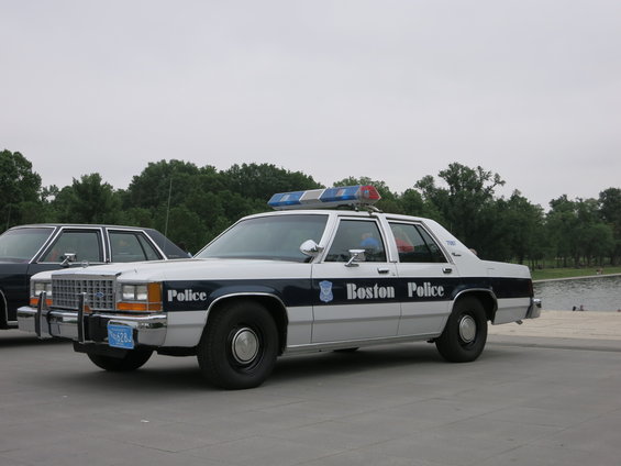 1991 Ford Crown Victoria police car, side view, white with blue stripe