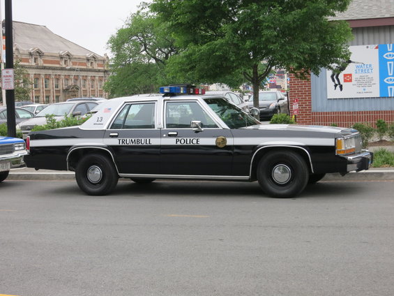 Black and white police car, 1991 Ford Crown Victoria, side view, with 'TRUMBULL POLICE' text