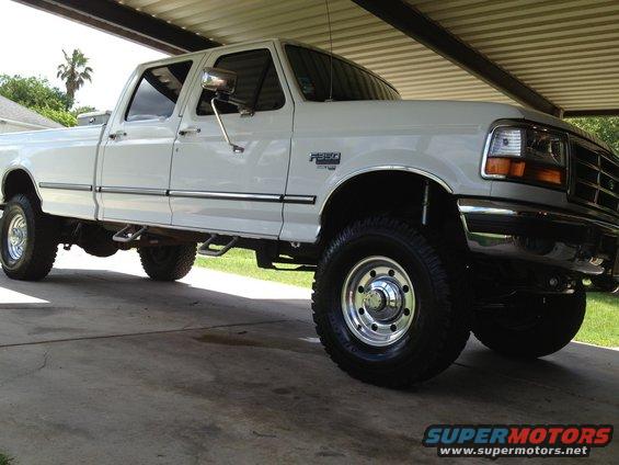 White 1997 Ford F-350 pickup truck, four-door cab, chrome trim, parked under a covered structure