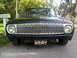1962 Ford Falcon - A black 1962 Ford Falcon is parked in front of a mailbox, its distinctive grille prominently displayed.