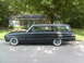 1962 Ford Falcon - Matte black 1962 Ford Falcon station wagon parked curbside in front of a house.