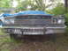 1974 Dodge Monaco - The front grille and headlights of a 1974 Dodge Monaco are visible, partially covered by a blue tarp.