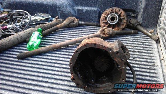 Differential housing, driveshaft, and hub assembly parts on a truck bed