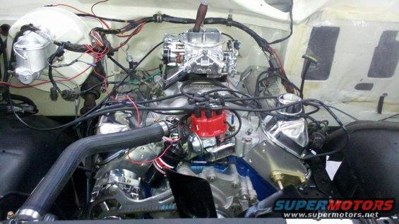 Engine bay of a 1982 Ford Bronco with a V8 engine, chrome accents, and aftermarket carburetor