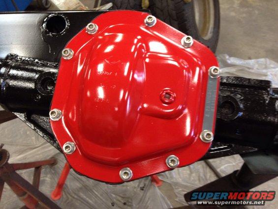 Red painted differential cover with silver bolts on a black axle housing
