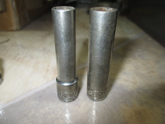 two metal socket wrenches on a table