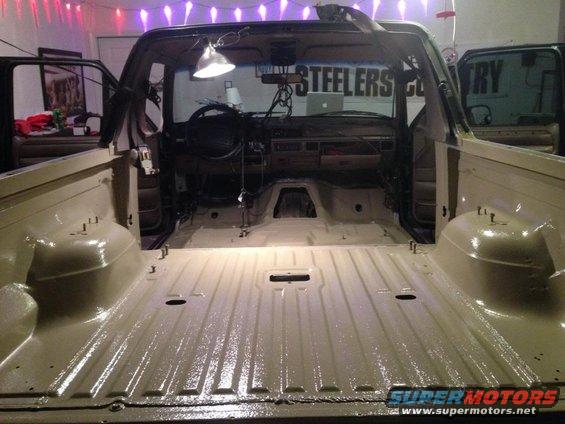Tan Ford Bronco interior with dashboard and empty bed, under construction
