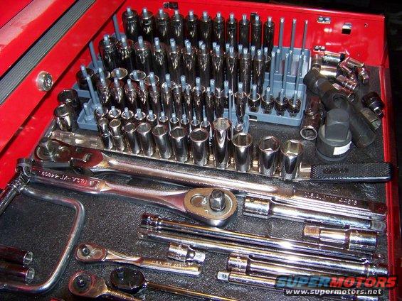 Tool chest drawer filled with various sockets and ratchets. Some text visible on tools
