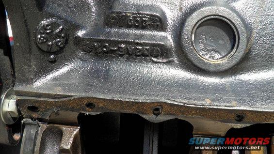 Close-up of a cast iron engine block with part numbers visible