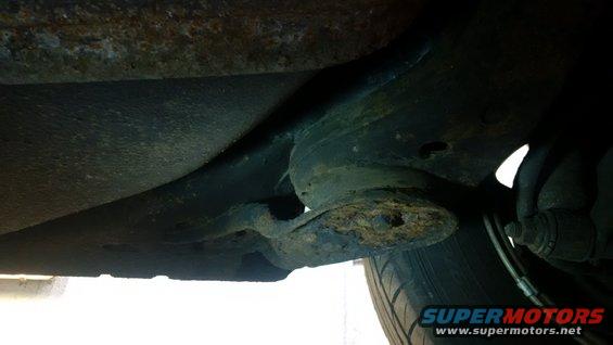 Underbody rust repair with visible frame damage and tire