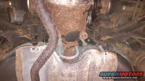 rusted exhaust pipe and suspension parts underneath a vehicle