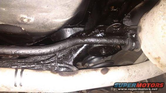 Underbody of a vehicle with black rustproofing applied to suspension components and frame rails