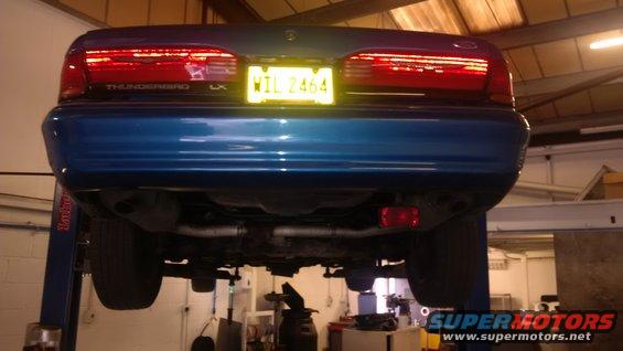 Blue 1994 Ford Thunderbird rear view, lifted on a hoist, showing undercarriage and license plate WIL 2464