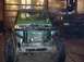 1992 Ford Bronco - A green Suzuki Samurai is parked in a garage next to a dark-colored truck.