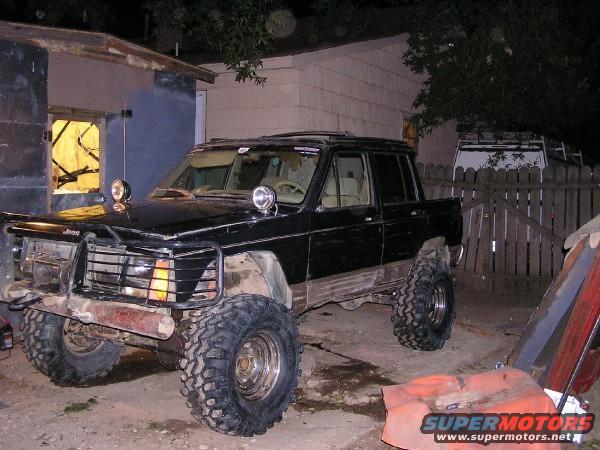 Black Jeep Comanche pickup truck with off-road tires and brush guard