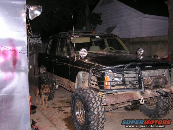 Black Jeep Comanche pickup truck with large tires and a brush guard