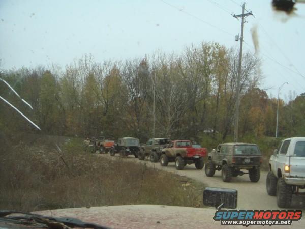 Line of lifted off-road vehicles driving on a dirt road