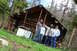 1989 Ford Bronco - A group poses for a photo in front of an old log cabin surrounded by trees.