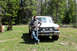 1989 Ford Bronco - A man poses with his white Ford pickup truck in a forest clearing.