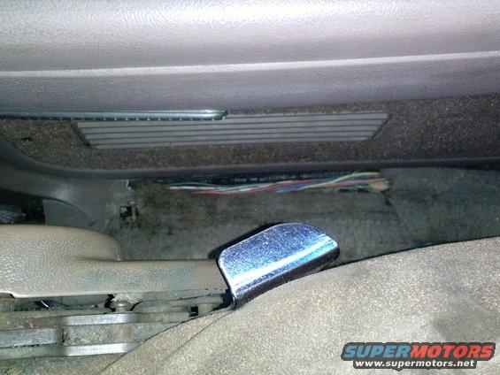 Close-up of exposed wiring under the seat of a vehicle