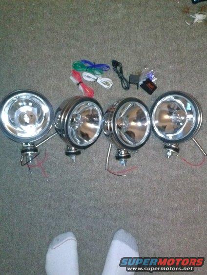 Four chrome fog lights with wiring and accessories