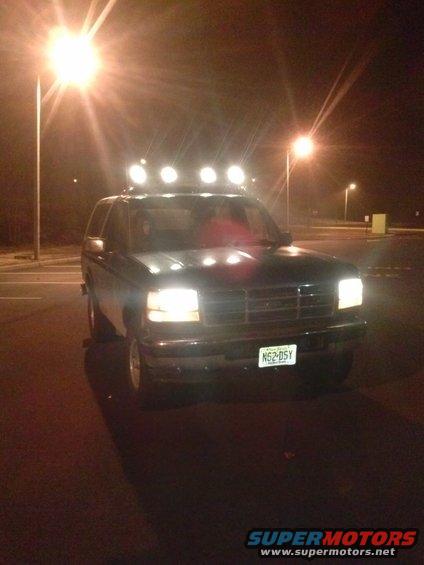 Front view of a 1996 Ford Bronco with a light bar on the roof at night