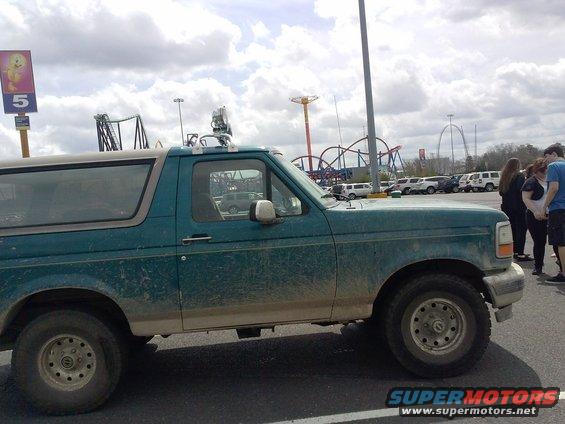 Side view of a green 1996 Ford Bronco with a light-colored roof and aftermarket lights
