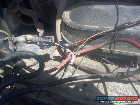 Close-up of engine bay wiring with black electrical tape repairs