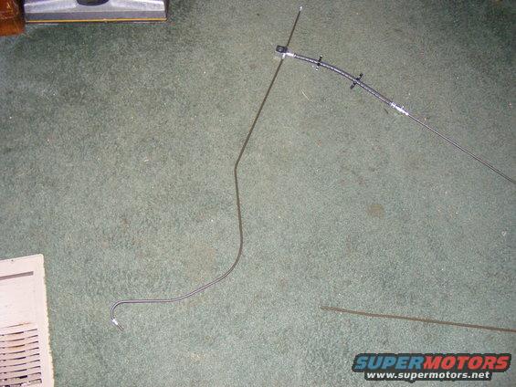 Brake line and vacuum hose laid out on carpet next to a vent