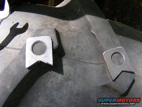 Close-up of a tire with two welded metal lugs and a wrench