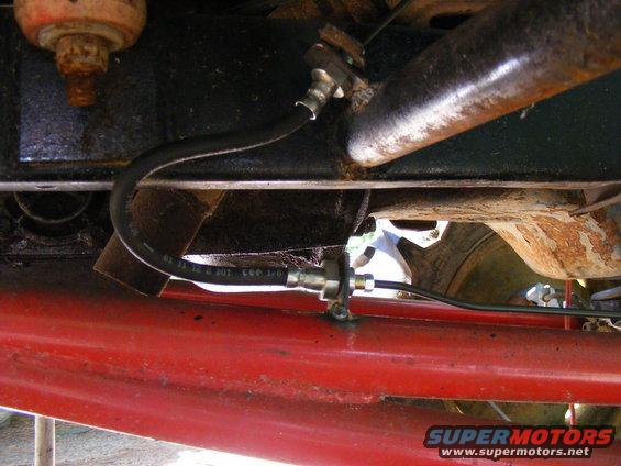 Close-up of a brake line on a red vehicle frame
