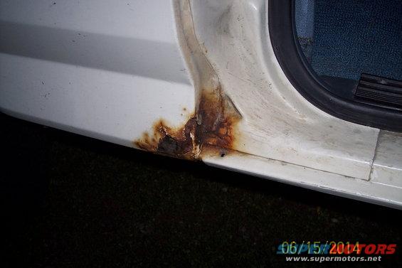 White vehicle door sill with significant rust damage near the bottom edge