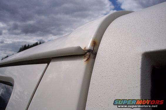 White SUV roofline showing rust damage at seam