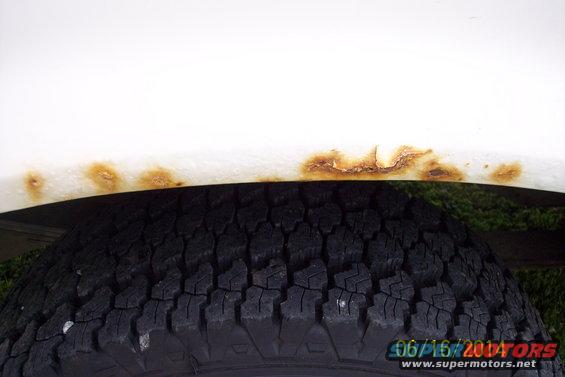 White fender with rust above tire. Date stamp reads 06/16/2004