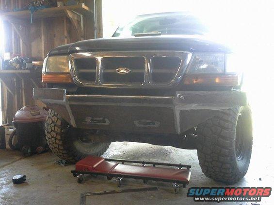 2000 Ford Ranger with custom front bumper and large tires in a garage