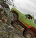 1990 Ford Bronco - A green off-road vehicle navigates a challenging rocky terrain.