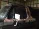 1978 Ford Bronco - The side of a black 1978 Ford Bronco is visible, with areas of rust and primer on the body panels.