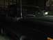 1978 Ford Bronco - A black truck cab and hood are visible in a dimly lit garage with another vehicle behind it.