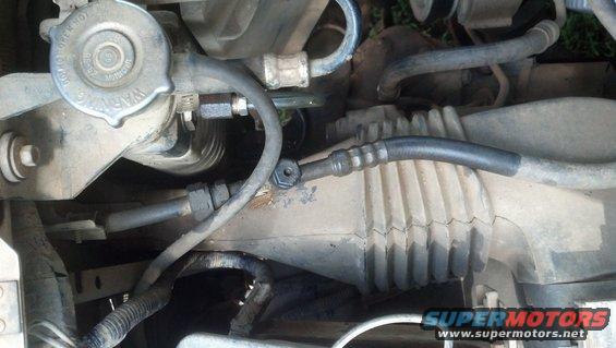 Power steering rack and pinion with hoses and warning cap